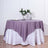 Purple tablecloth draped elegantly over a white skirted table with floral centerpiece.