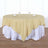 Round gold tablecloth draped over a white table with glasses and napkins.