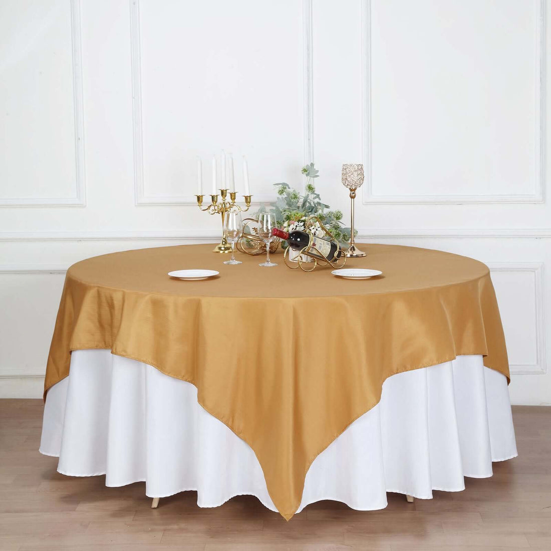 Round gold satin tablecloth on a dining table with elegant decor.