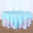 Round table set with a light blue tablecloth and white linens.