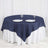 Navy tablecloth draped over round table with plates and glasses