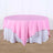 Round pink tablecloth draped over a white table.