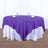 Purple round tablecloth draped elegantly on a white table.