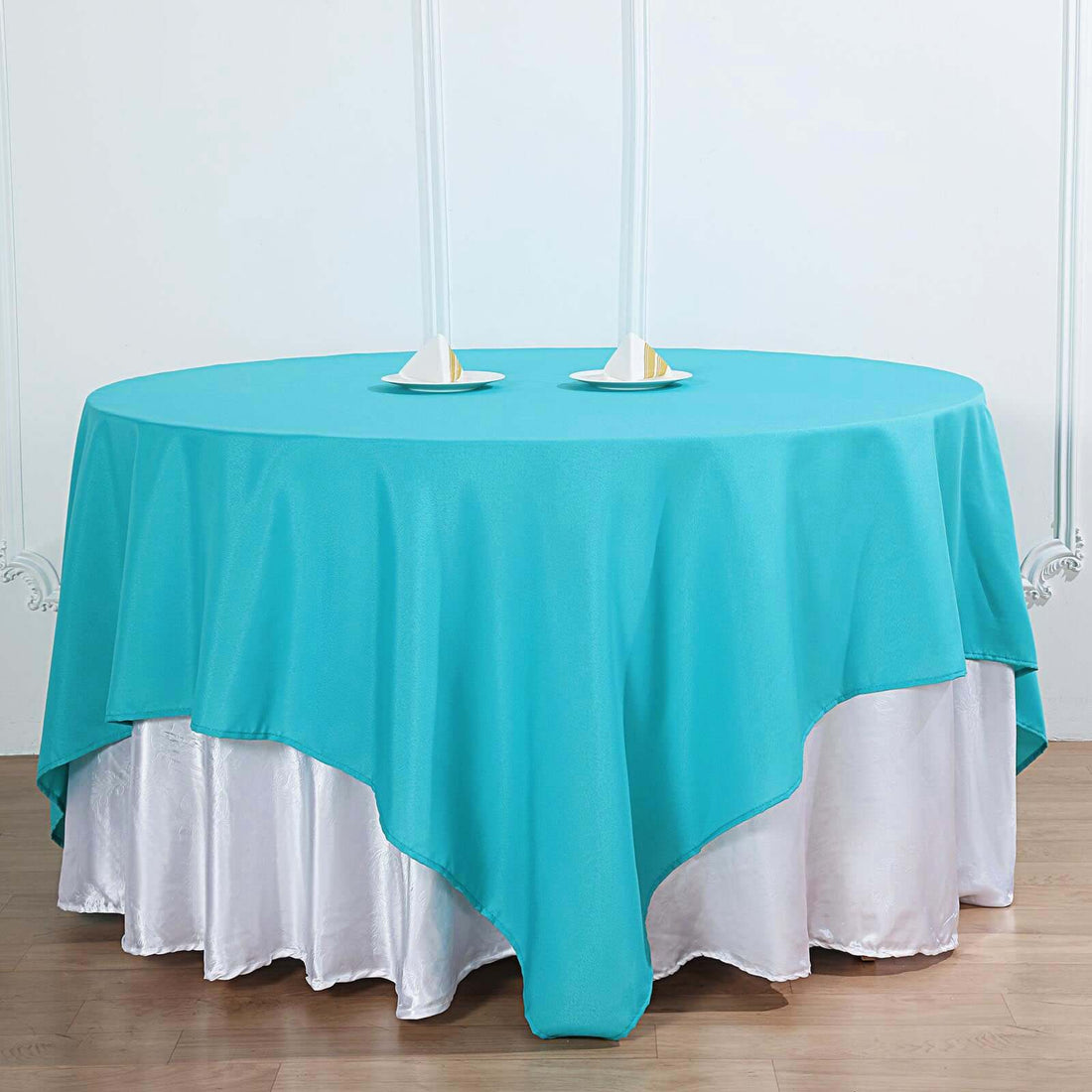 Turquoise tablecloth draped over a white table for elegant dining.
