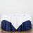 Round table dressed with white and navy tablecloth, set for dining.