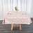 Pink geometric tablecloth with gold accents on a wooden table.