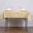 Elegant yellow tablecloth with dinnerware and wine glasses set for a formal dining experience.