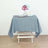 Gray tablecloth draped over a white wooden table with a flower vase and dessert plates.
