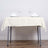 Elegant cream tablecloth draped over a dining table with plates and glasses.