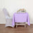 Purple tablecloth draped over a table with a floral centerpiece.