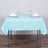 Mint green tablecloth draped over a table set with glasses and napkins.