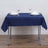 Navy tablecloth on a dining table set with plates and glasses.