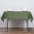 Green tablecloth draped over a table set with plates and glasses.