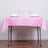 Pink tablecloth draped over a table set with glasses and napkins.