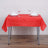 Red tablecloth set on a table with white napkins and glasses.