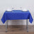 Blue tablecloth set on a dining table with glasses and napkins.