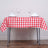 Red and white checkered tablecloth with plates and glasses on a dining table.