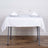 Dining table set with white tablecloth and elegant glassware.