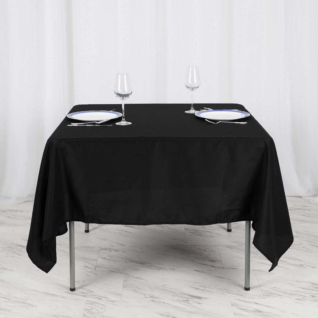 Black tablecloth draped elegantly over a dining table set for two.