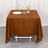 Brown tablecloth draped over a table set with a plate, glass, and flowers.