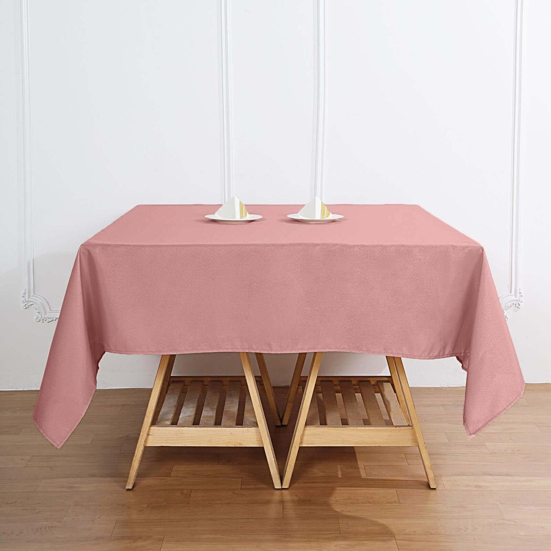 Pink tablecloth on a wooden table with candles