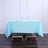 Light blue tablecloth on a wooden table set for dining.