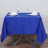 Blue tablecloth set for dining with glasses and napkins on a wooden floor.