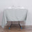 Gray tablecloth draped over a table set with glasses and napkins.