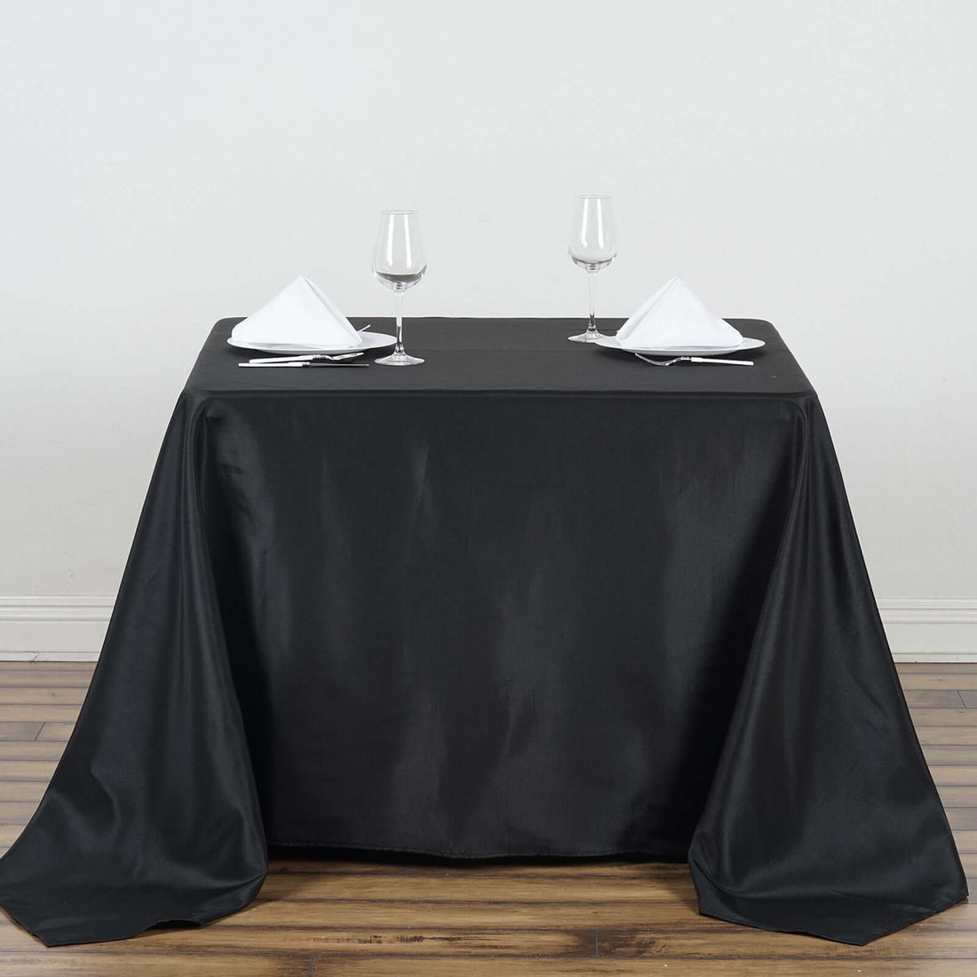 Elegant black tablecloth draped on a table set for dining.