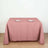 Pink tablecloth draped over a dining table set with plates and utensils.