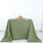 Green tablecloth draped elegantly on a table with plates and a floral centerpiece.