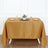 Elegant gold tablecloth draping over a dining table with decorative settings.