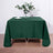 Green tablecloth draped over a wooden table with floral centerpiece.