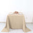 Beige tablecloth draped over a table with plates and a bouquet of roses.