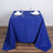 Blue tablecloth draped over a table set for two with glasses and plates.