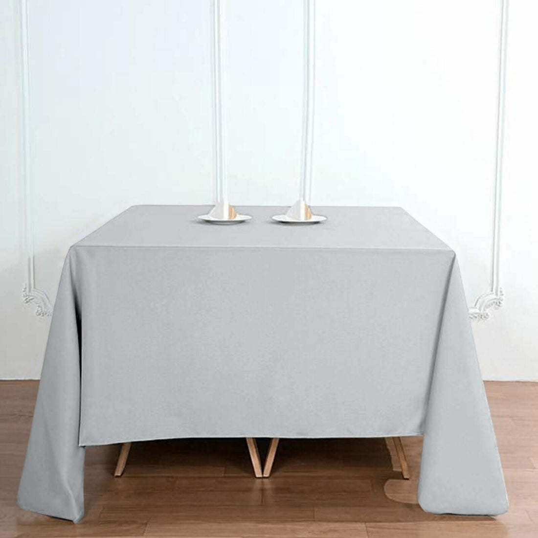 Gray tablecloth on a wooden table with candle holders