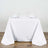 Elegant white dining table setup with glasses and napkins.