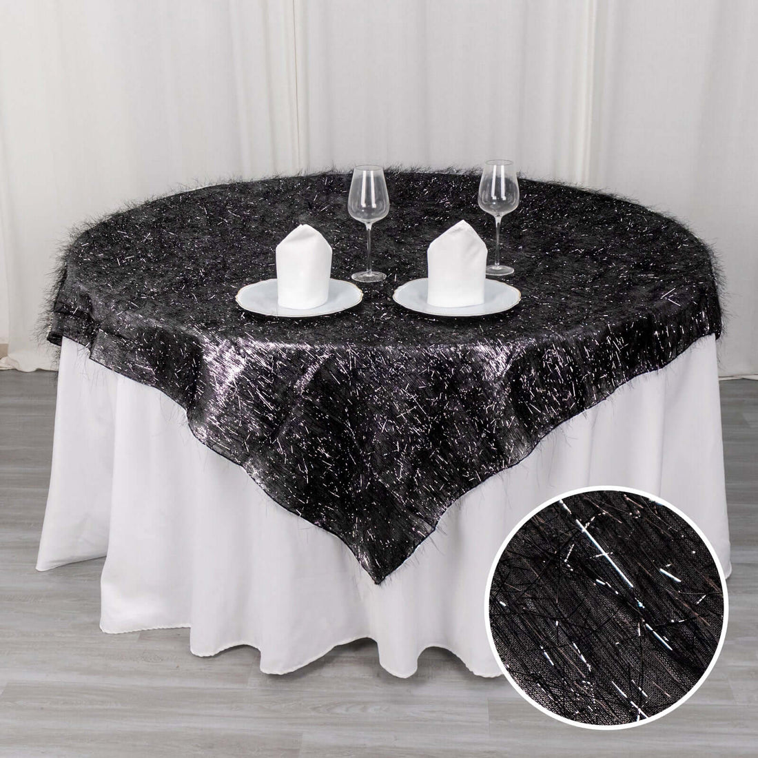 Black sheer table overlay with silver accents on a round table