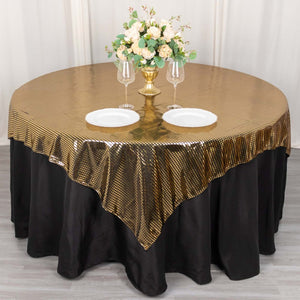 Round table with gold sequin tablecloth, black skirt, and floral centerpiece.