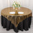 Round table with gold sequin tablecloth, black skirt, and floral centerpiece.