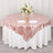 Rose gold tablecloth with elegant floral centerpiece and dinnerware.