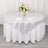 Round table set with silver tablecloth and floral centerpiece.