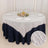 Elegant round table set with a white textured tablecloth and decorative centerpiece.