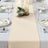 Elegant beige table runner on a dining table set for a formal meal.