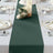 Elegant dark green table runner on a beautifully set dining table with floral decor.