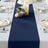 Navy blue table runner on a dining table set with plates and decor.