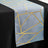 Blue table runner with gold geometric pattern on a black table.