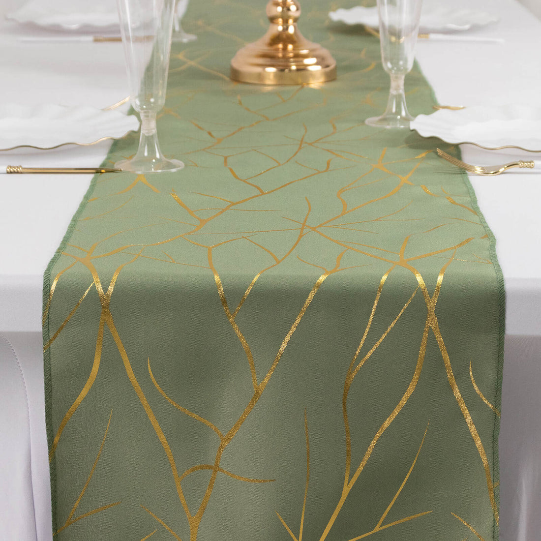 Gold leaf patterned table runner on a green background.