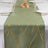 Gold leaf patterned table runner on a green background.