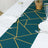 Teal table runner with gold geometric pattern on a dining table setting.